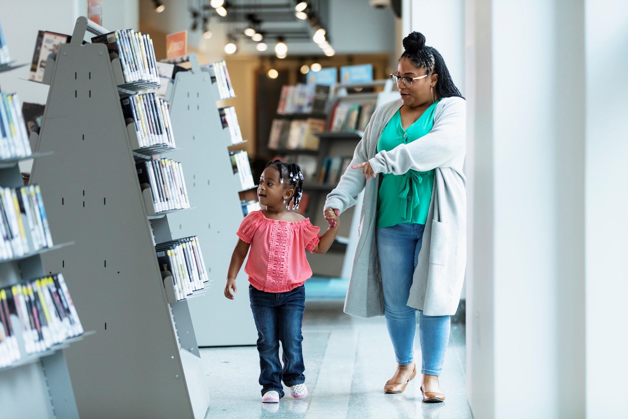 Mother and Young Daughter Walking Through the Library