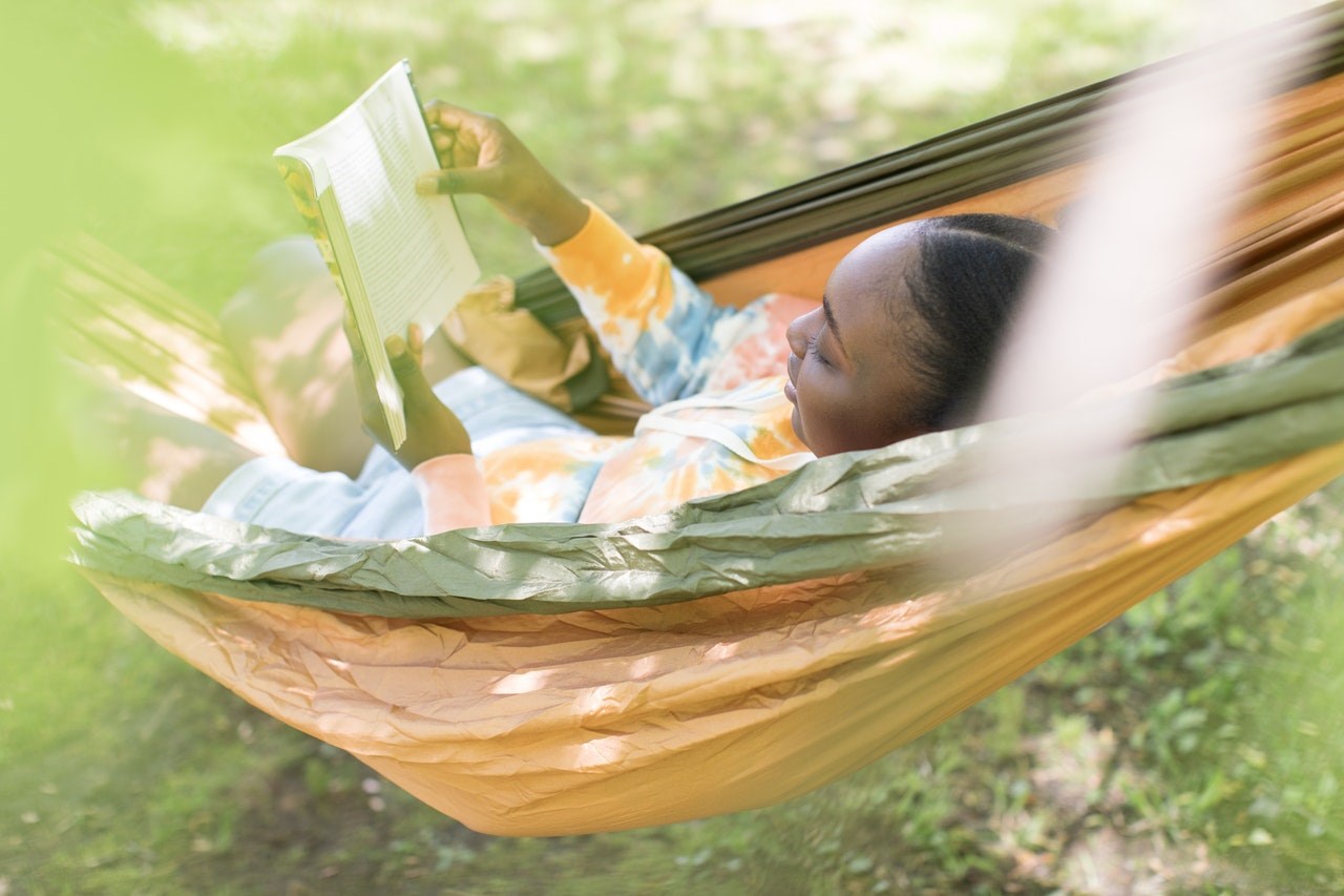 Woman Reading a Book in a Hammock Outdoors