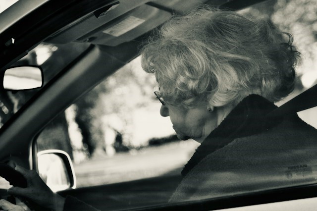 An older woman drives a car.
