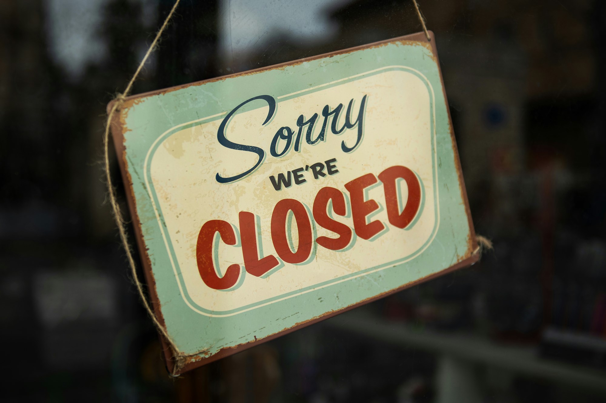 A photo of a sign reading "Sorry we're closed" in a window.