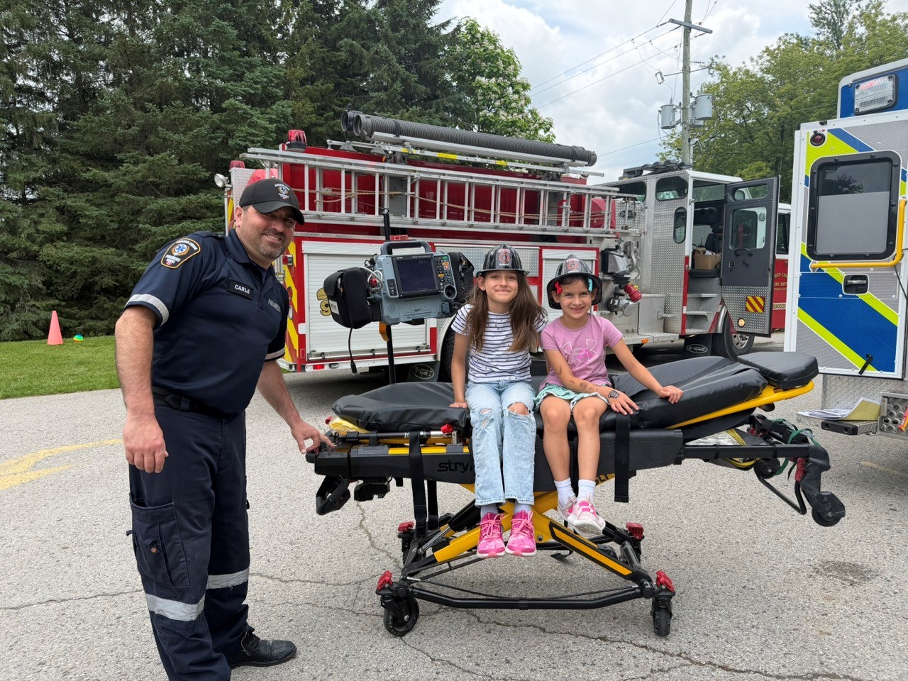 Two children sitting on a stretcher at the Thorndale Library's touch a truck event. 