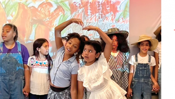 two little girls are performing together with their friends also performing in the back