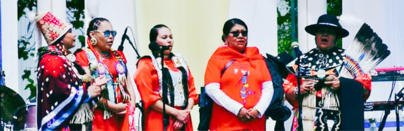 five singers in traditional Native dress