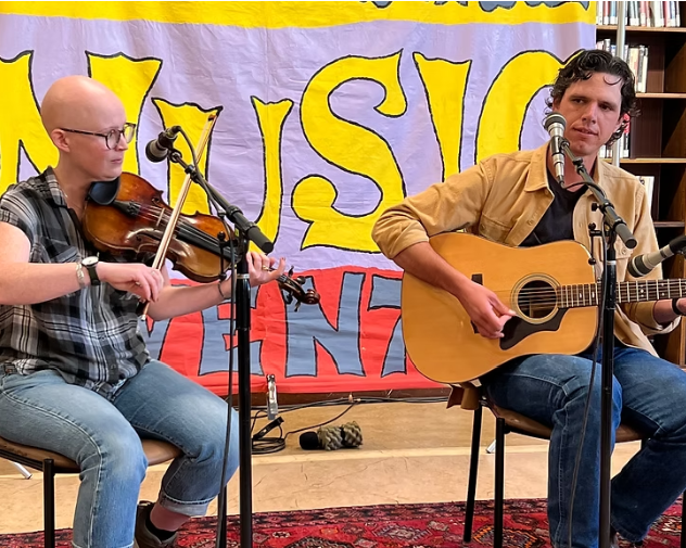 Two musicians playing fiddle and guitar