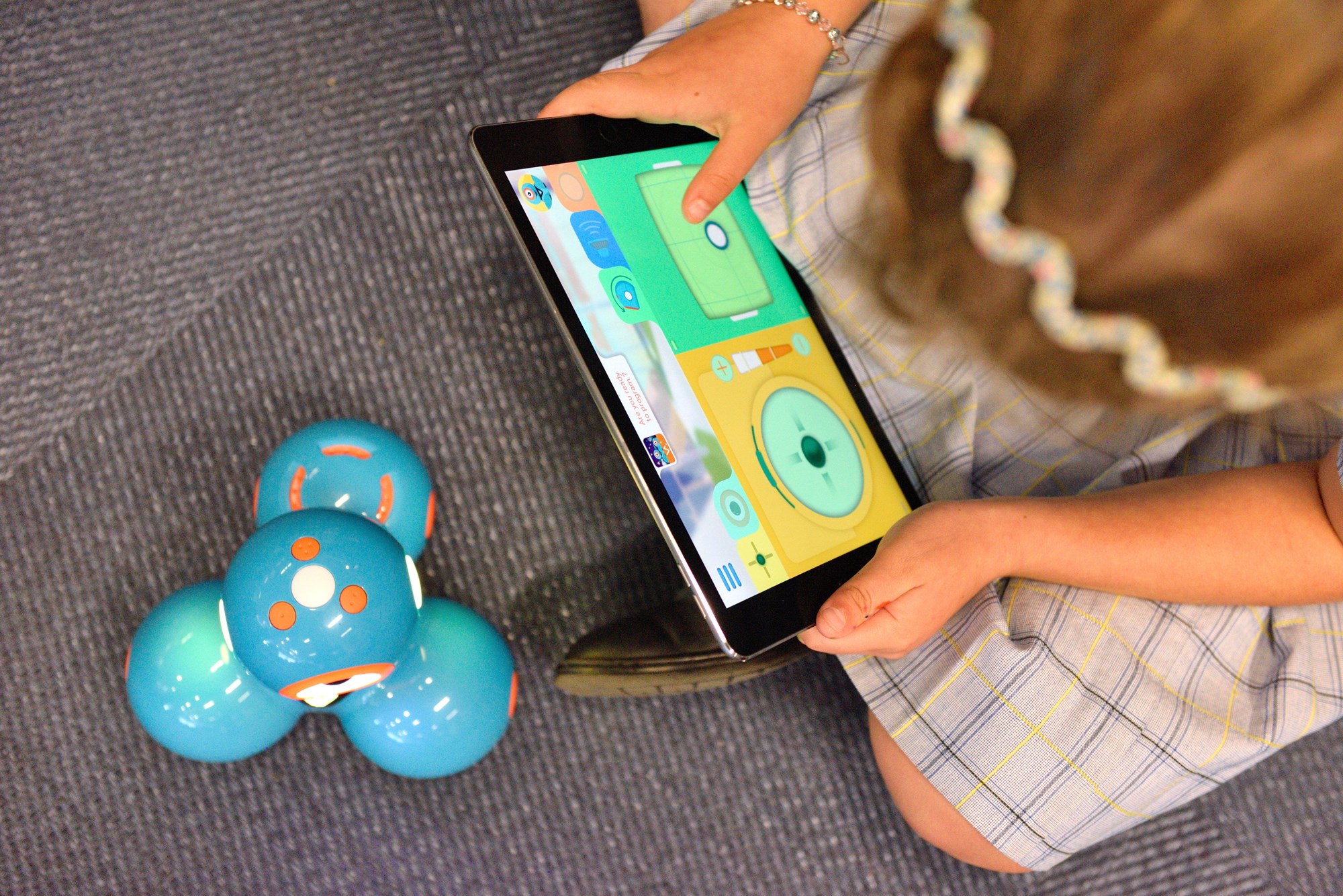 Girl Programming a Robot with a Tablet