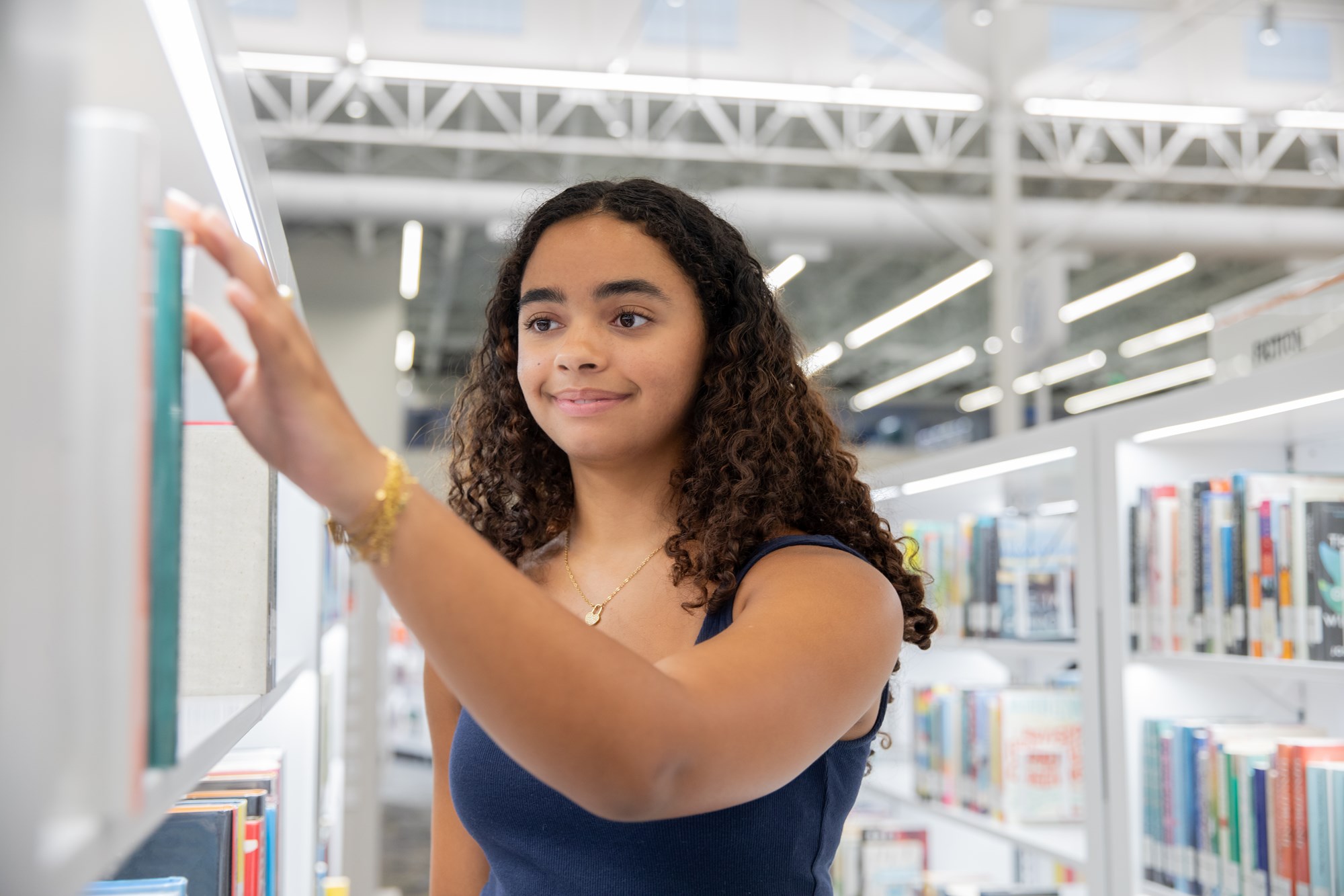 A Teenager Looks Through The Shelves at the Local Library