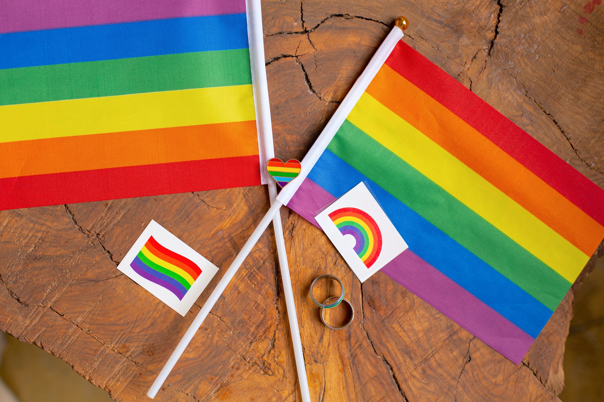 Two Rainbow Flags on Wooden Background