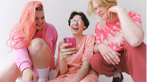 Female Friends in Pink Dresses Using Smartphone