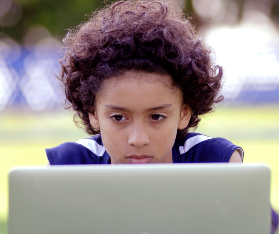 A student views their laptop screen with a slightly worried expression.