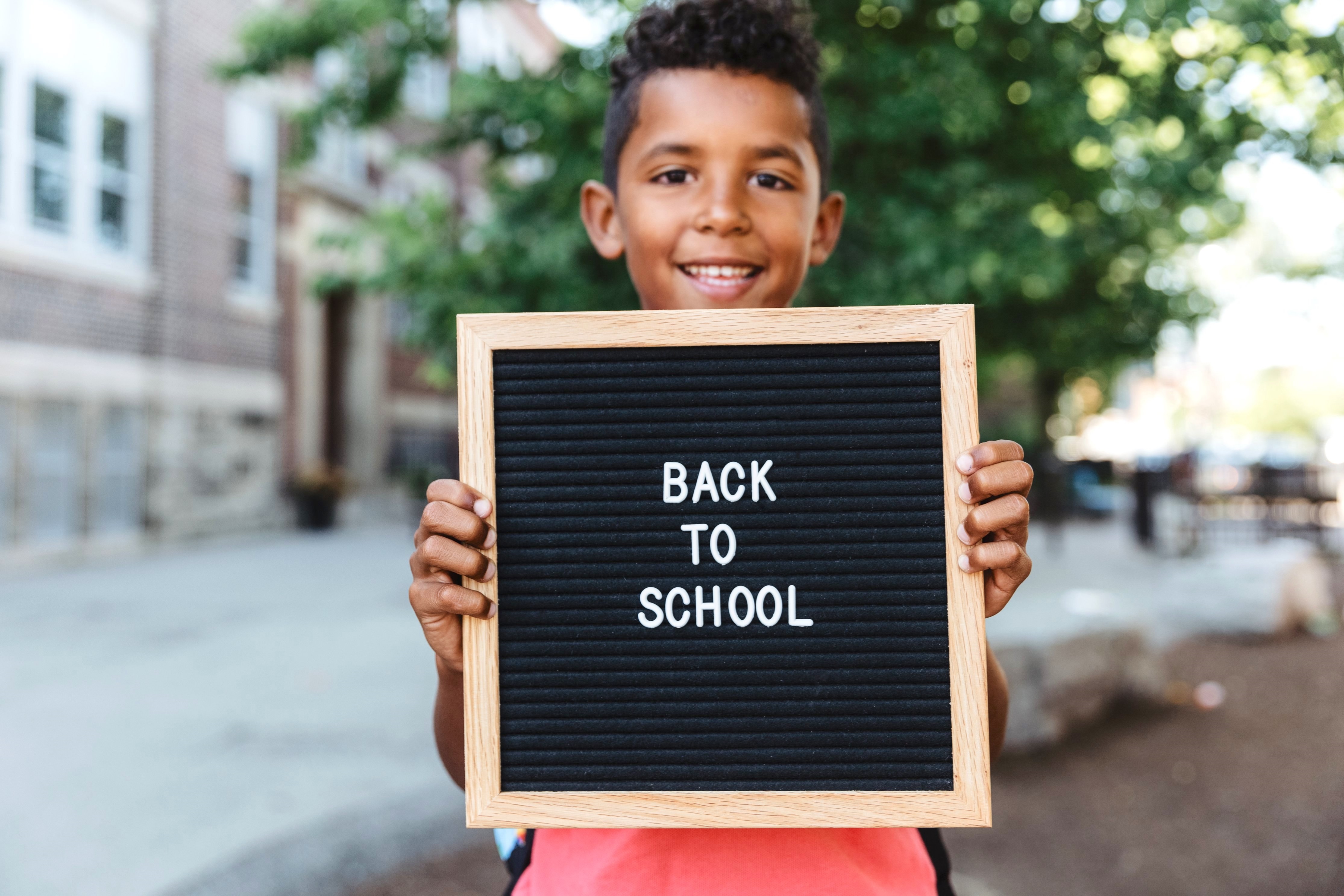Boy Holding Up a Back to School Pegboard 1