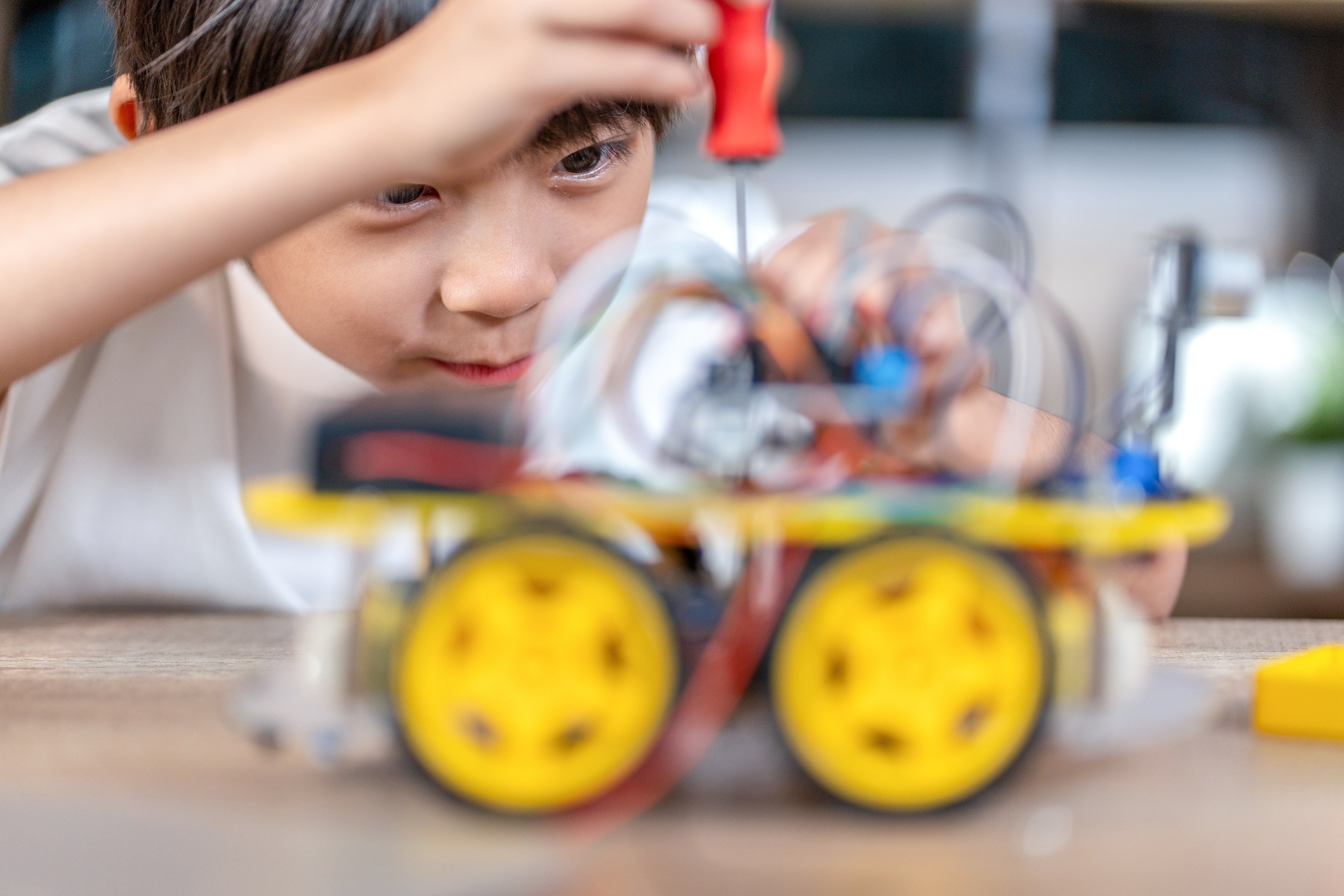 Boy Constructing Robotic Toy with Electric Gears
