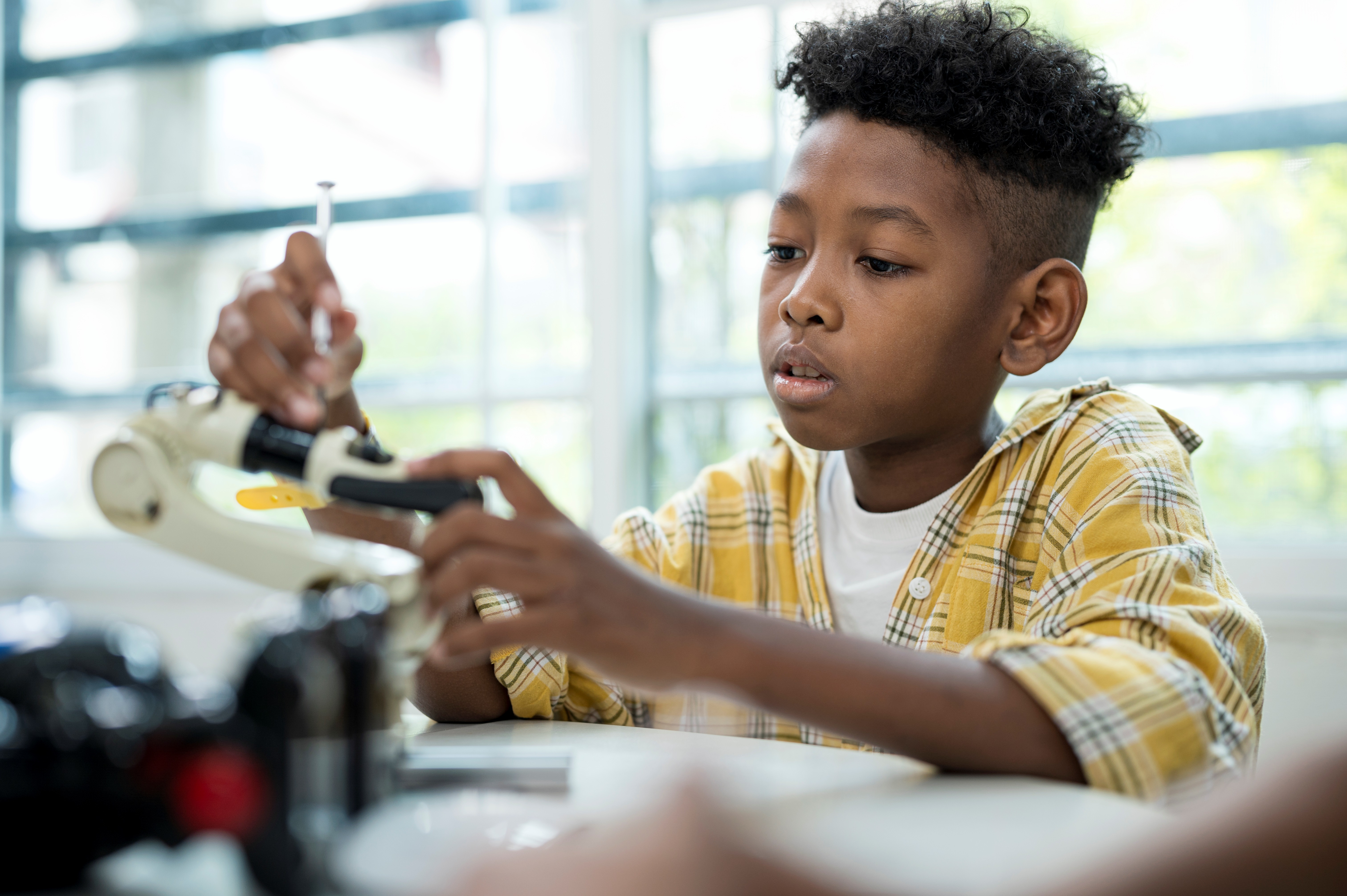 Young Boy Building Robotics Set in Library