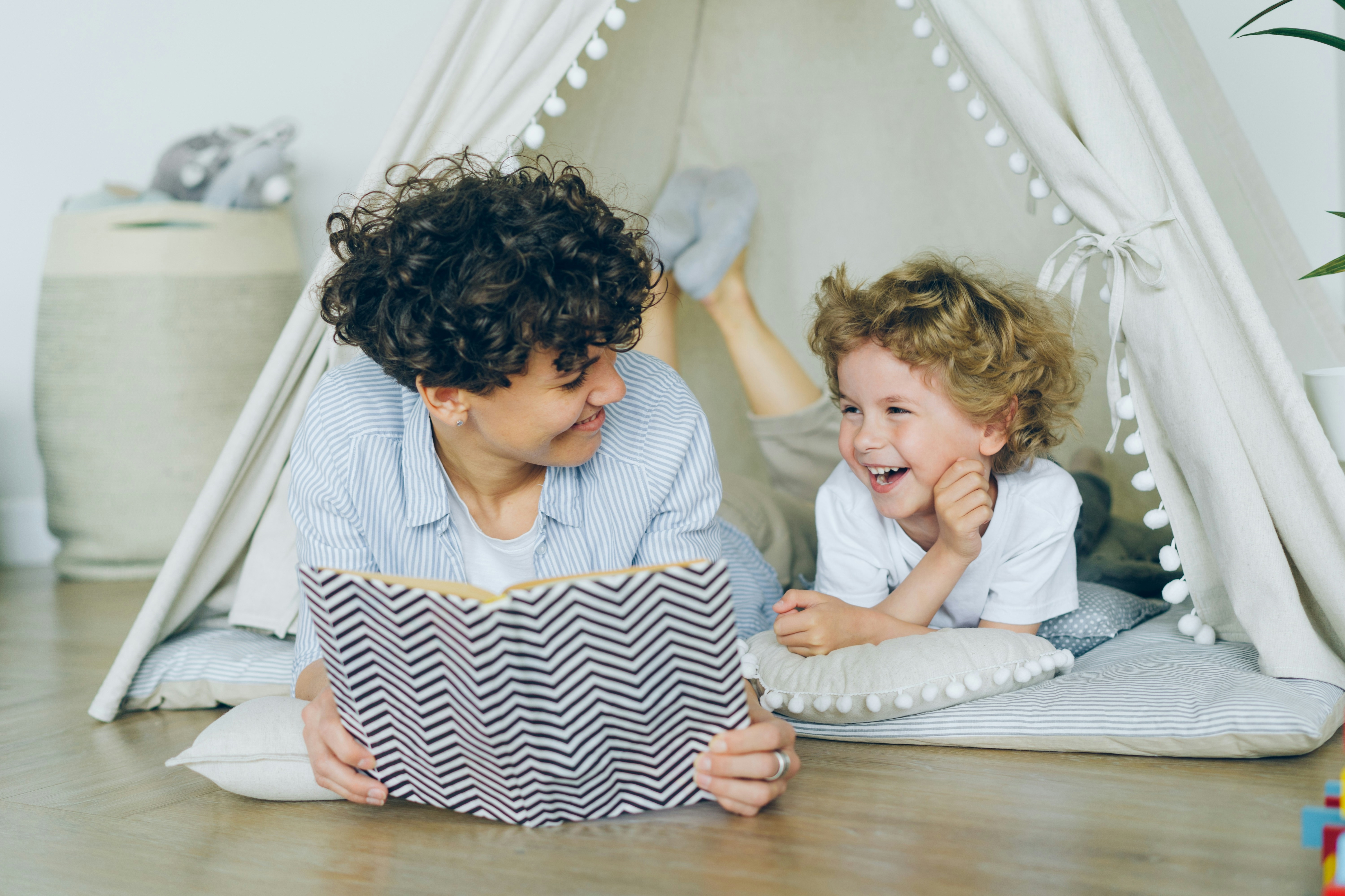 Mother Reading Book to Child Under a Tent