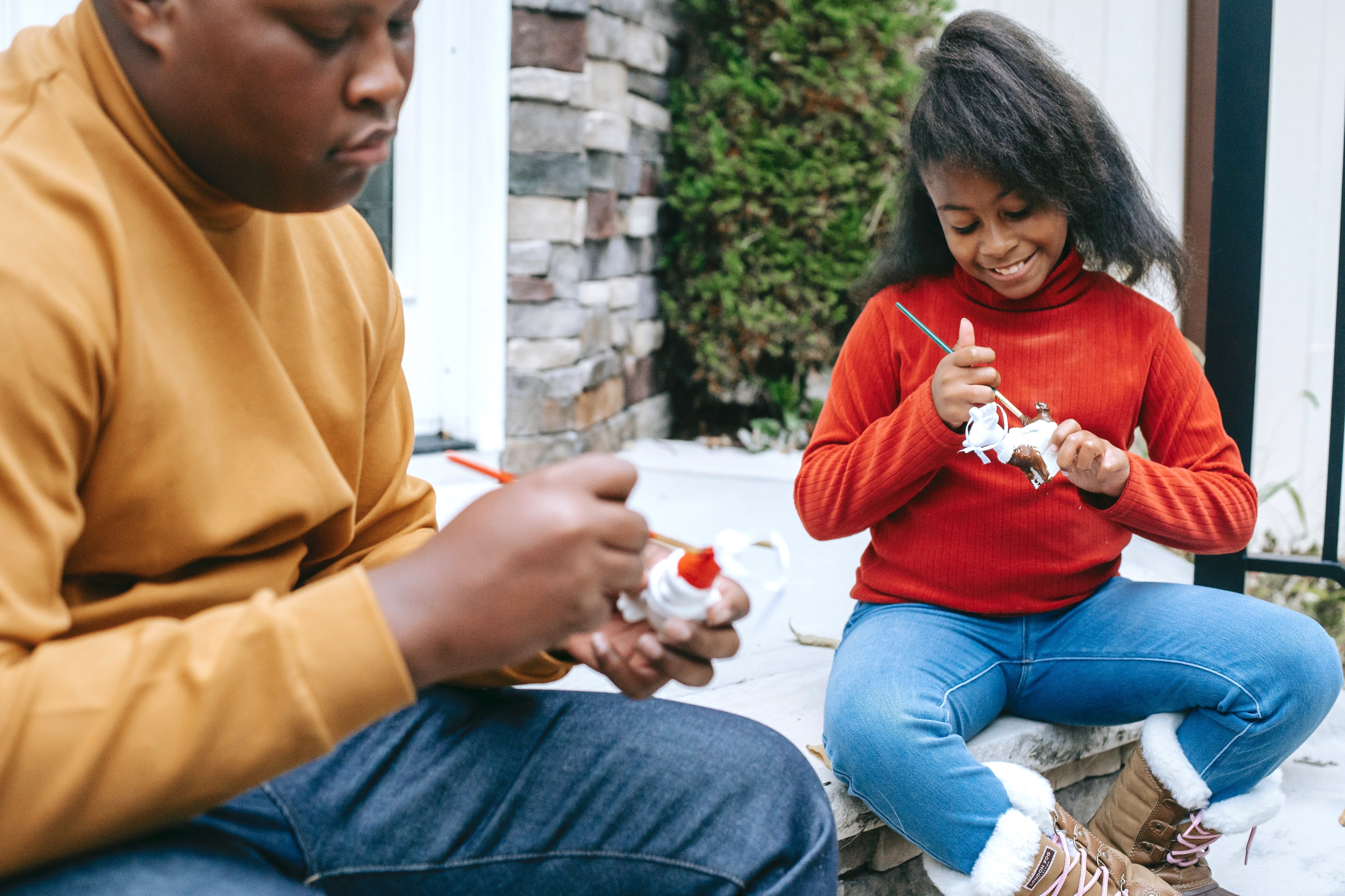 Siblings Painting Christmas Ornaments Outdoors