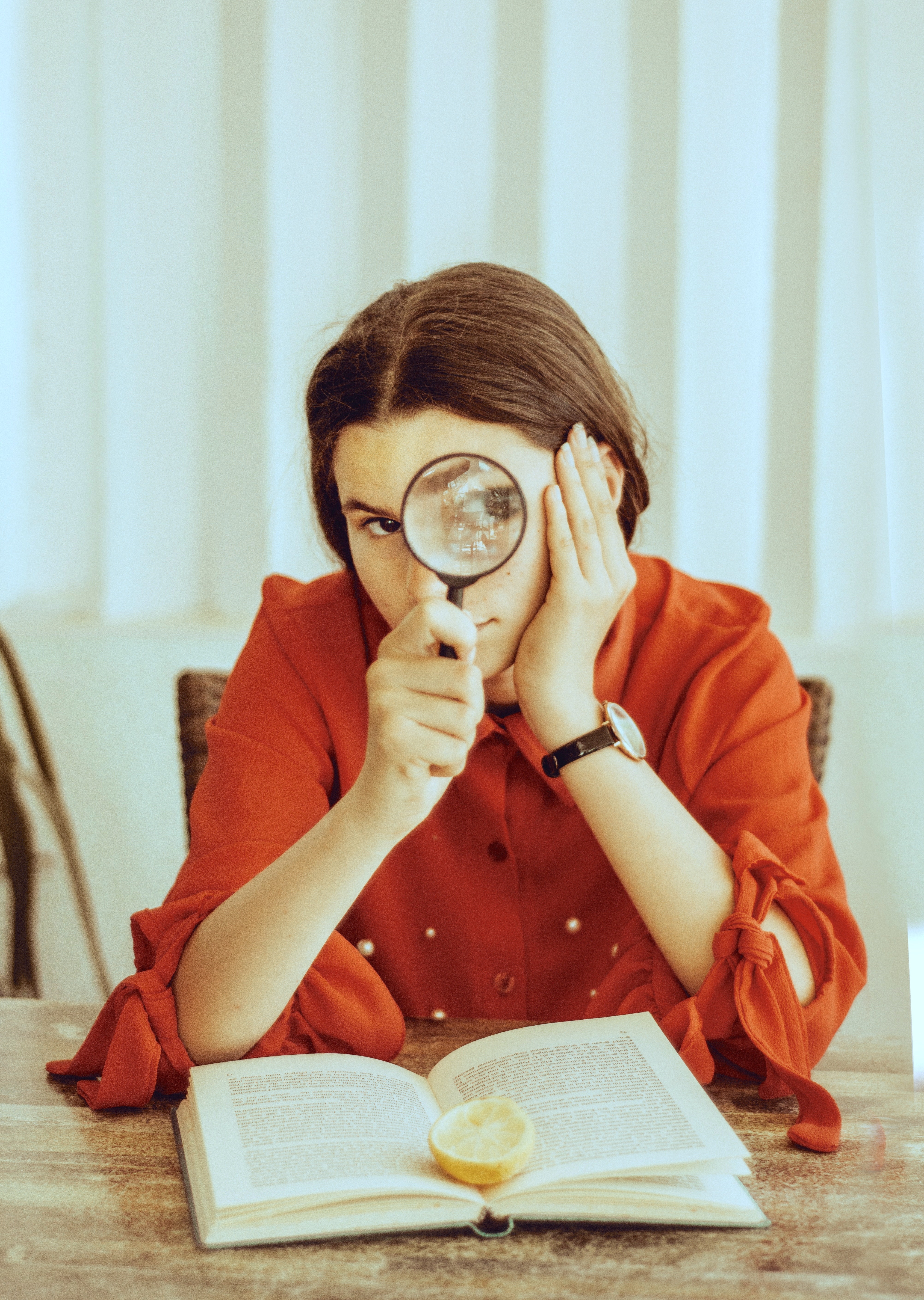 Picture of a teen with a magnifying glass and a book 