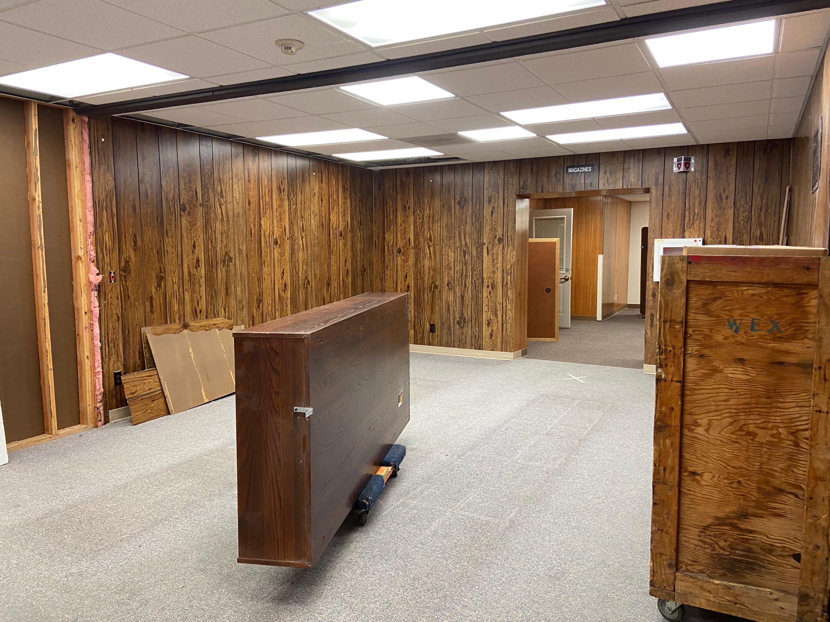 Image of a bookcase being moved in an empty space