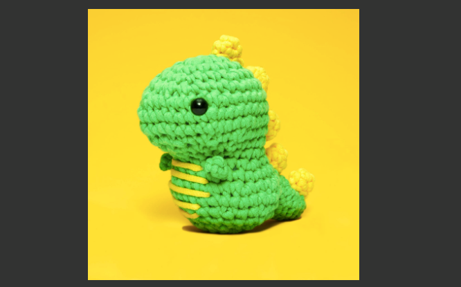 Photo of green and yellow crochet dinosaur