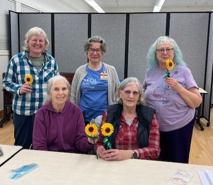 Photo of five people holding LEGO sunflowers created in the Bricks for Better Brains program.