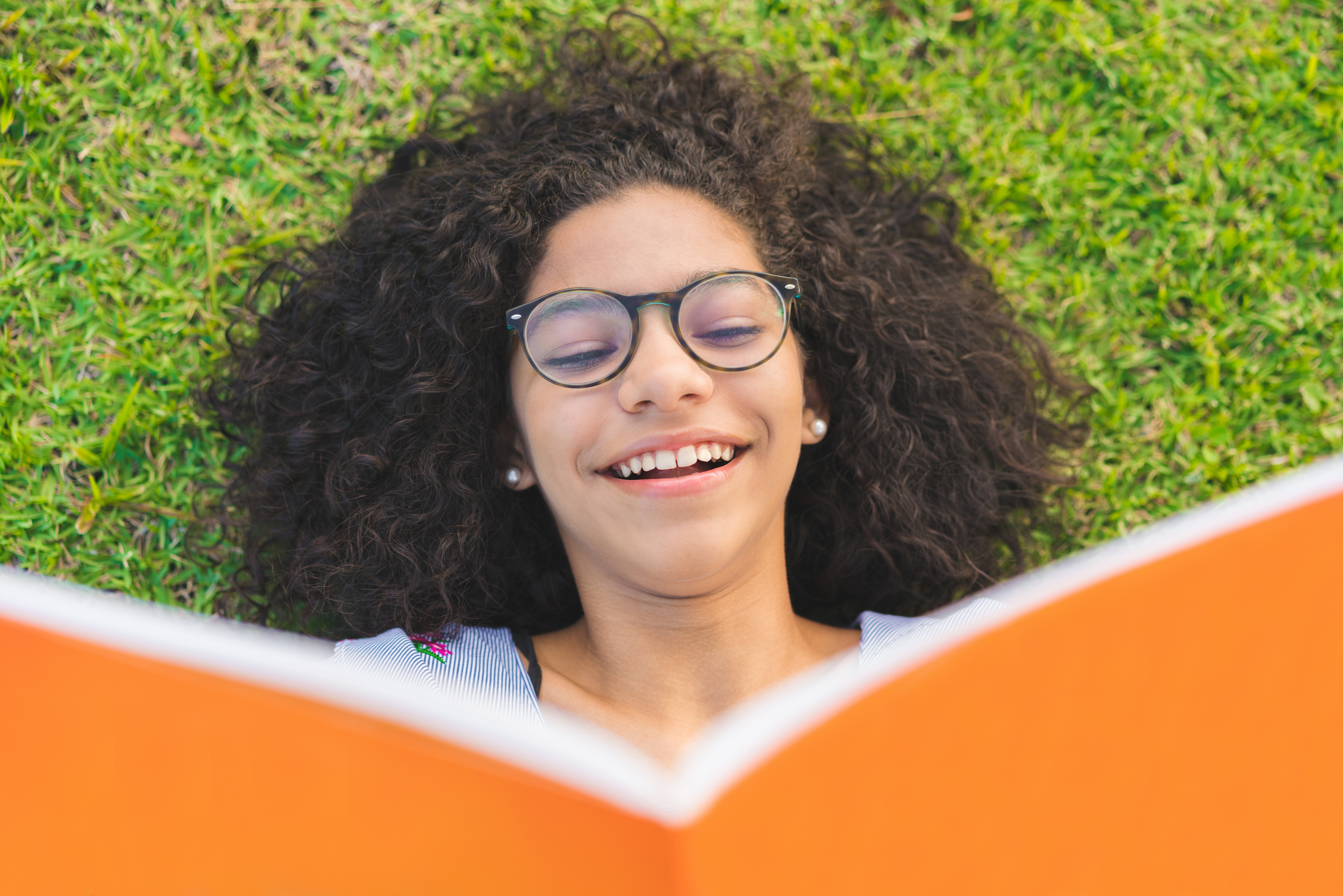 Girl in Glasses Smiling and Reading