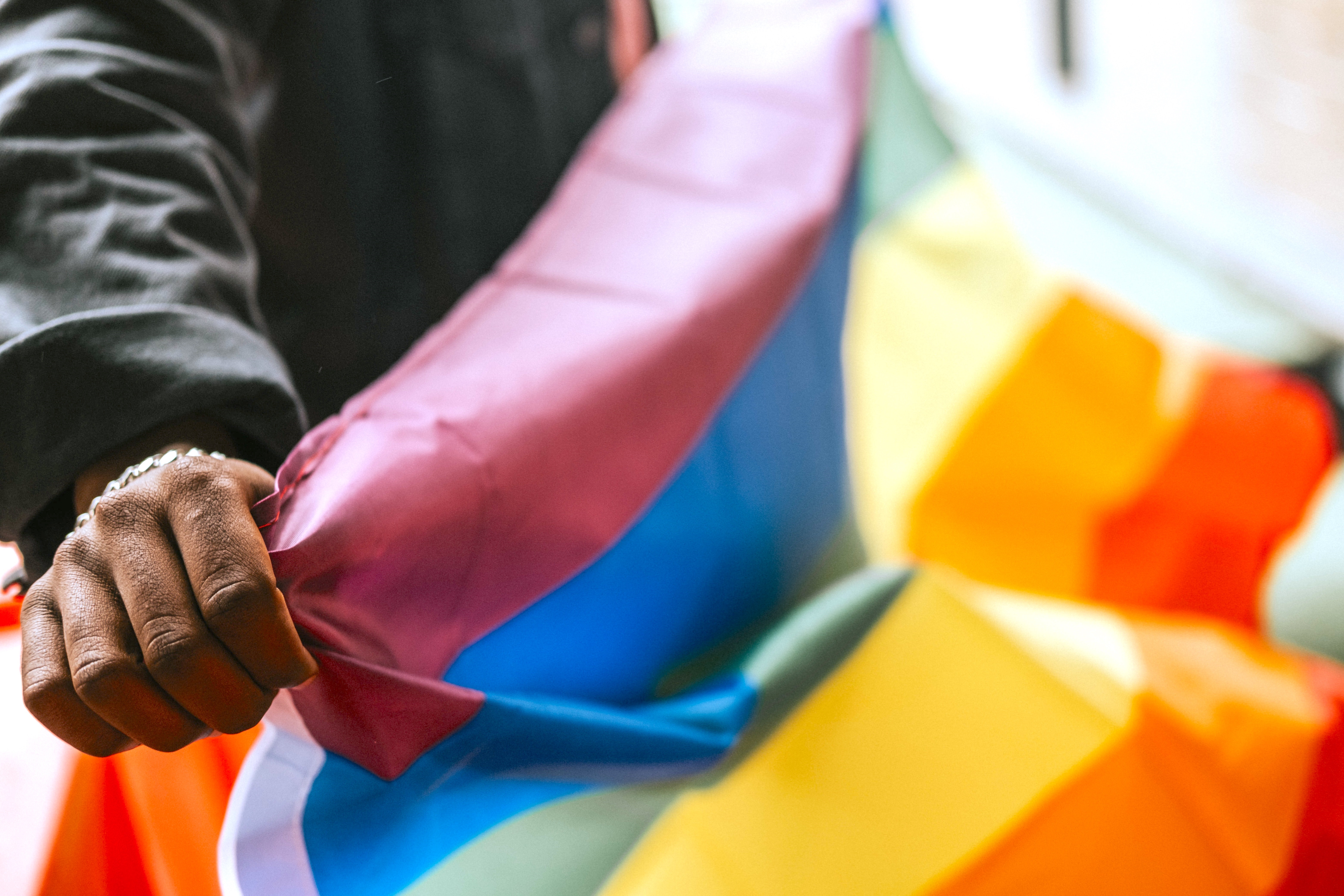 Close Up of Person Holding Rainbow Flag