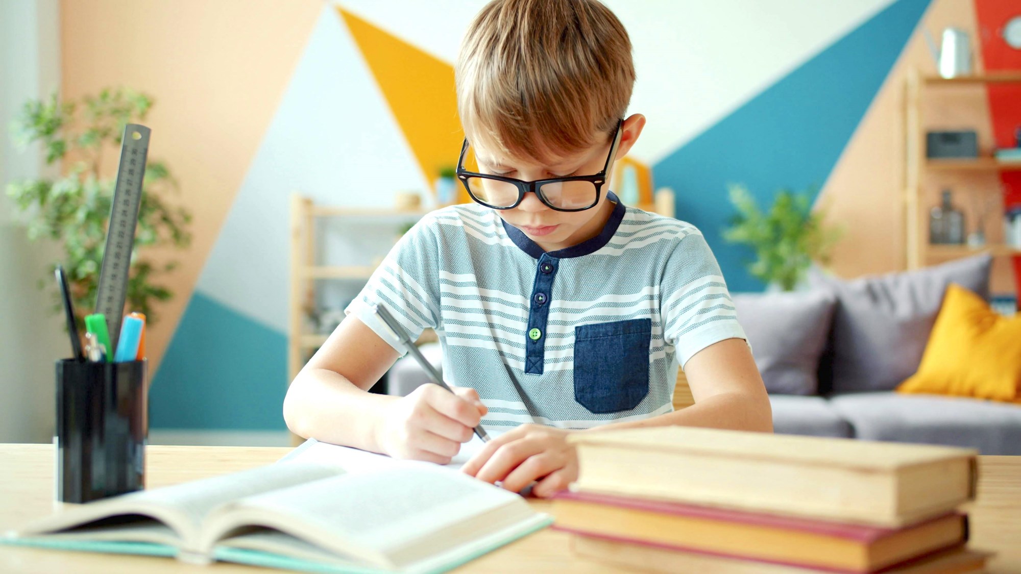 Young Boy Writing at Desk in Colorful Room