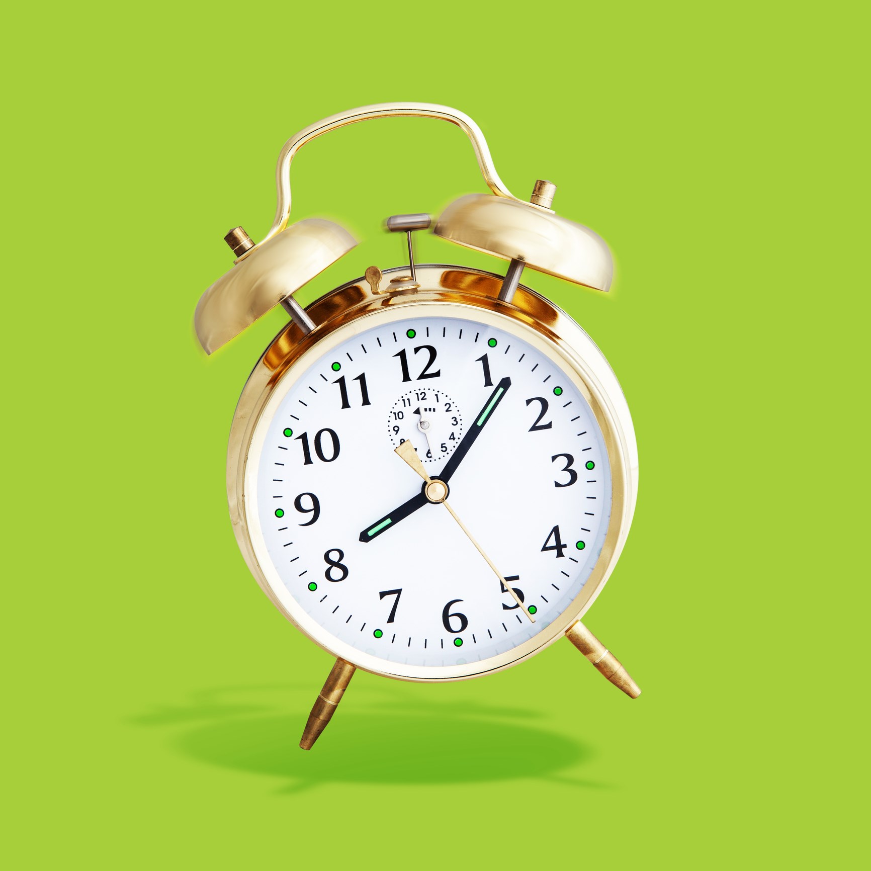 Gold Alarm Clock on Bright Green Background