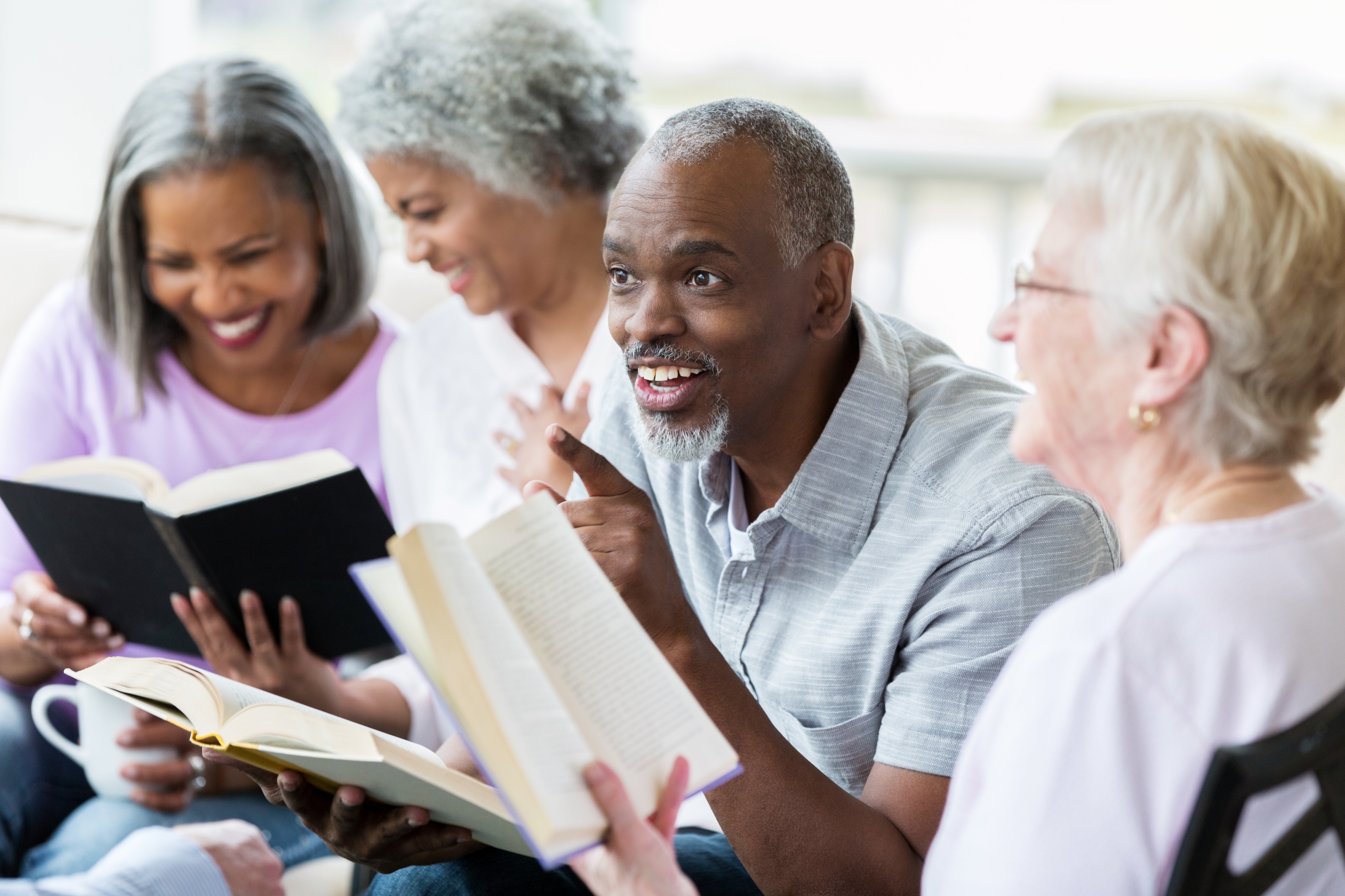 Group of three people discussing a book.