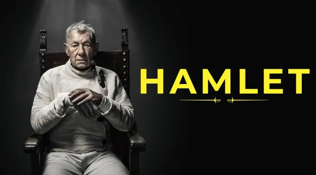 Man sitting in a throne with the word HAMLET beside him. 