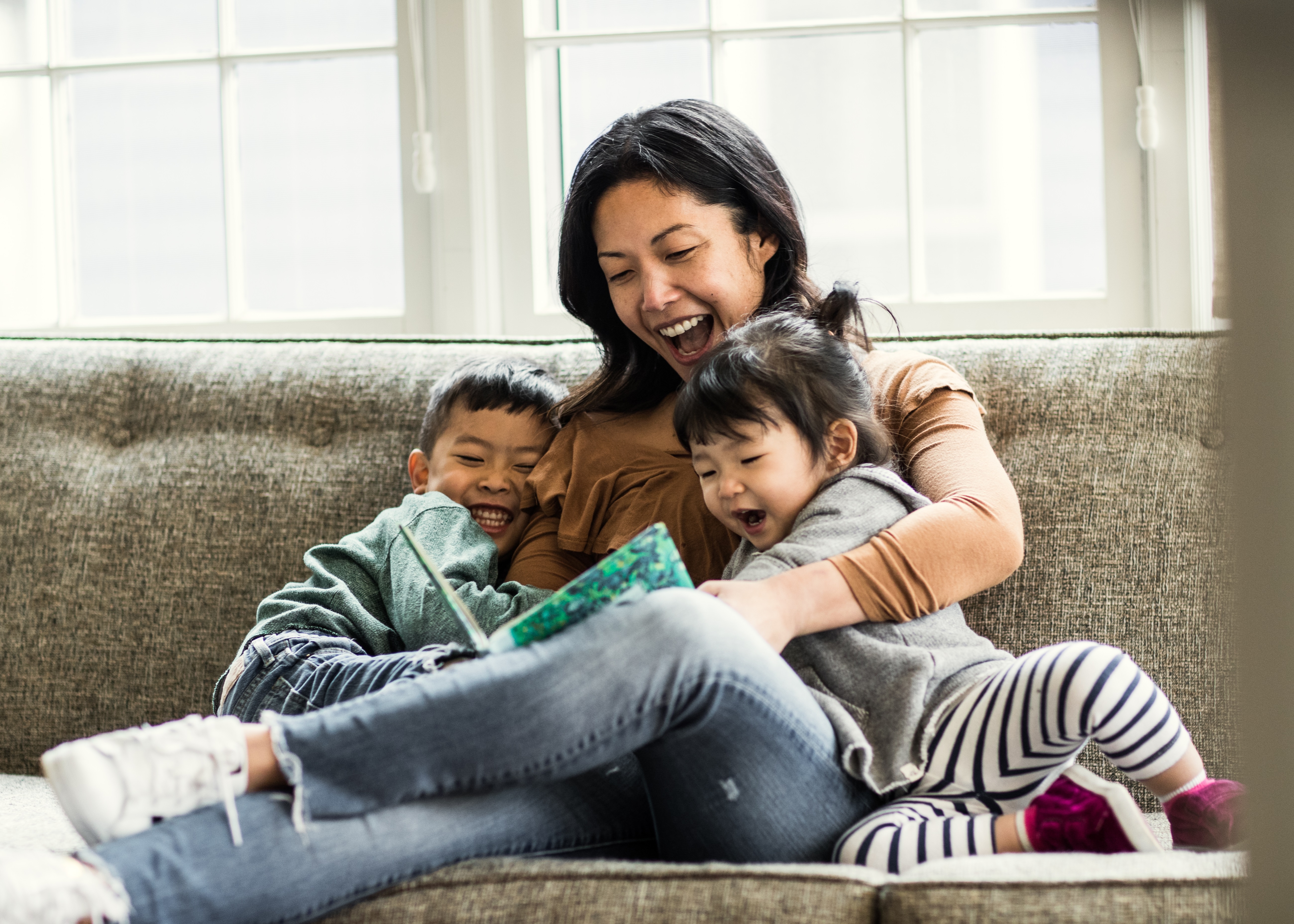 Mother Reading a Book to Kids on Couch
