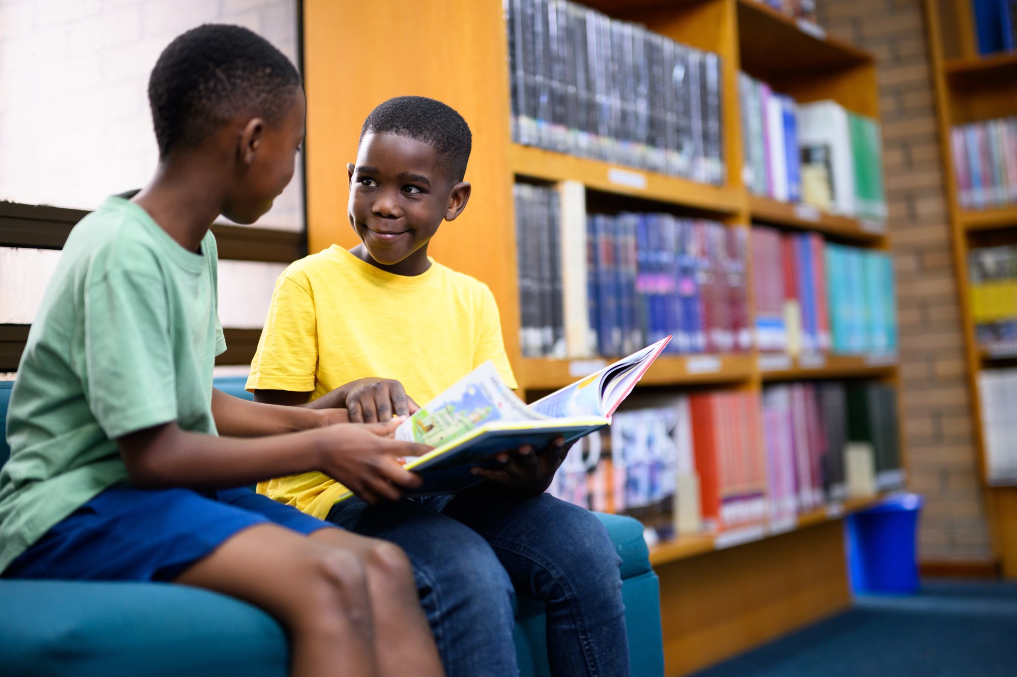two young boys sharing a book two young boys sharing a book
