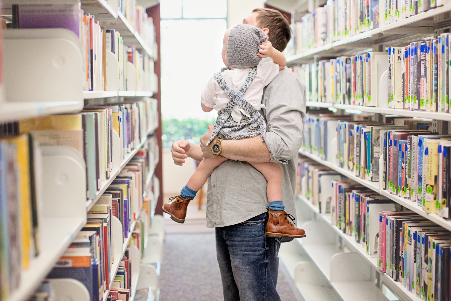 father and baby at the library looking at the book stacks father and baby at the library looking at the book stacks