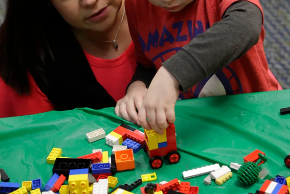 adult and child playing with LEGOs