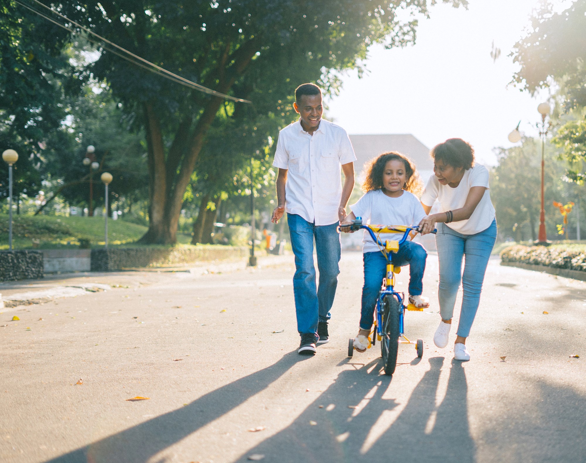father and mother with a child on a bike
