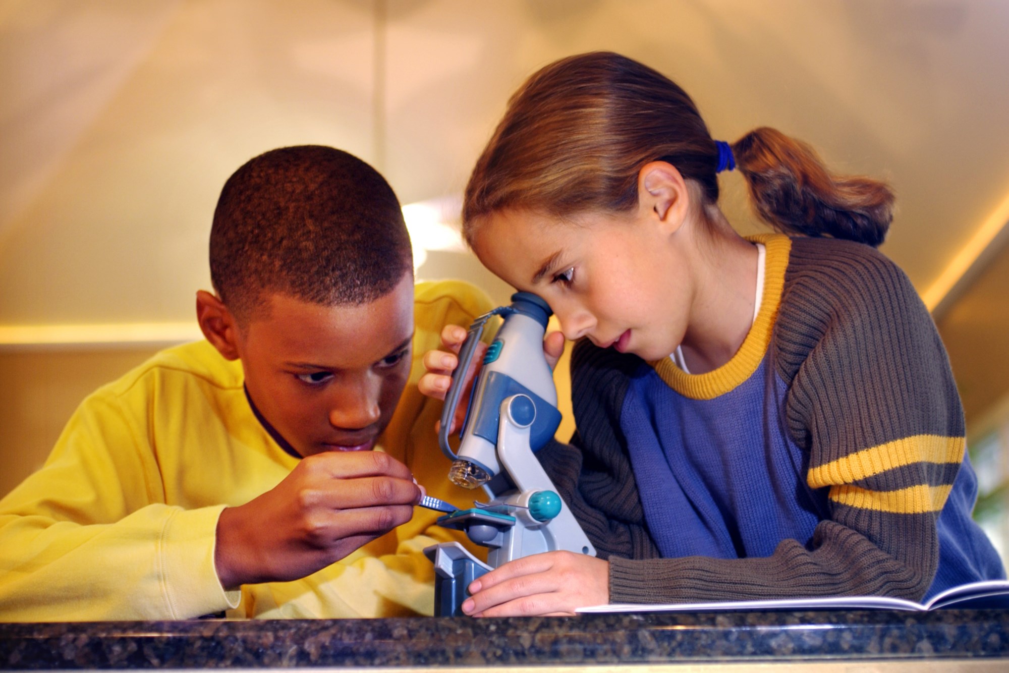 two kids using a microscope