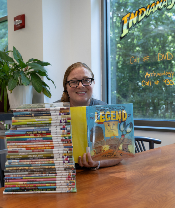 Library staff worker holding The Legend of Rock Paper Scissors.