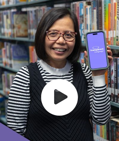 Smiling woman holding a phone with Transparent Language app.