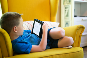 Child using a device to read.