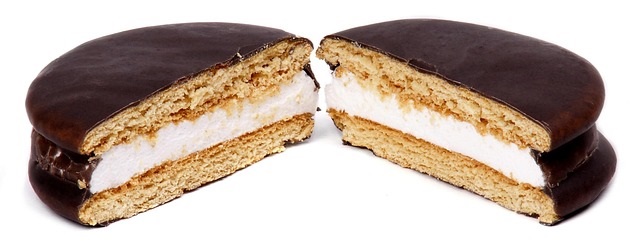 A moon pie cut in half to show the filling on the inside.