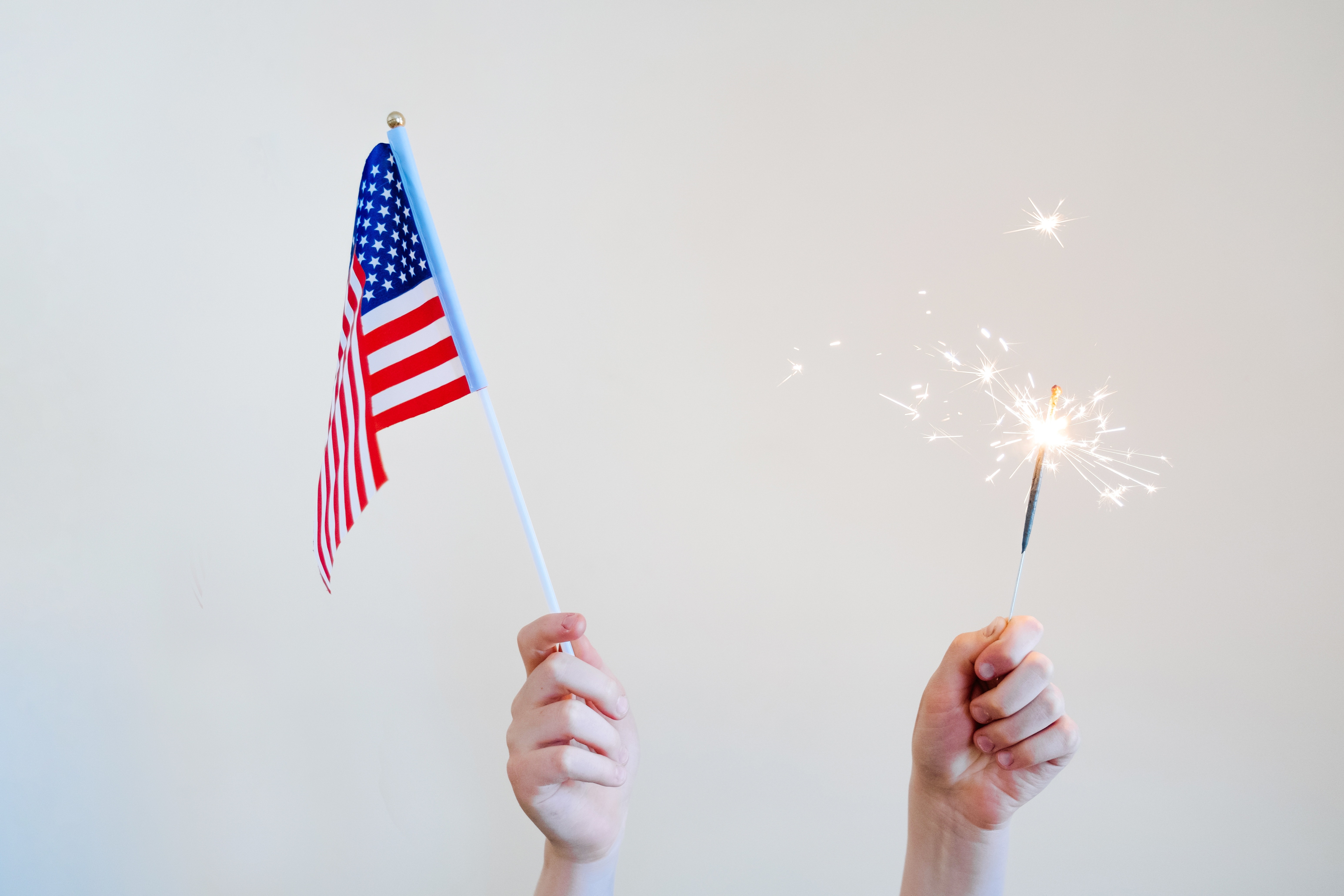 Person Holding an American Flag and Sparkler