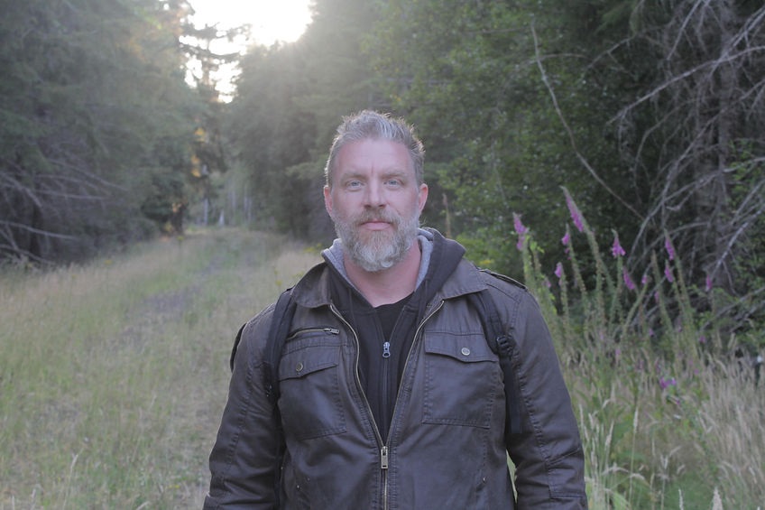 Photo of Ronnie LeBlanc standing in a grassy path, with trees on the edges