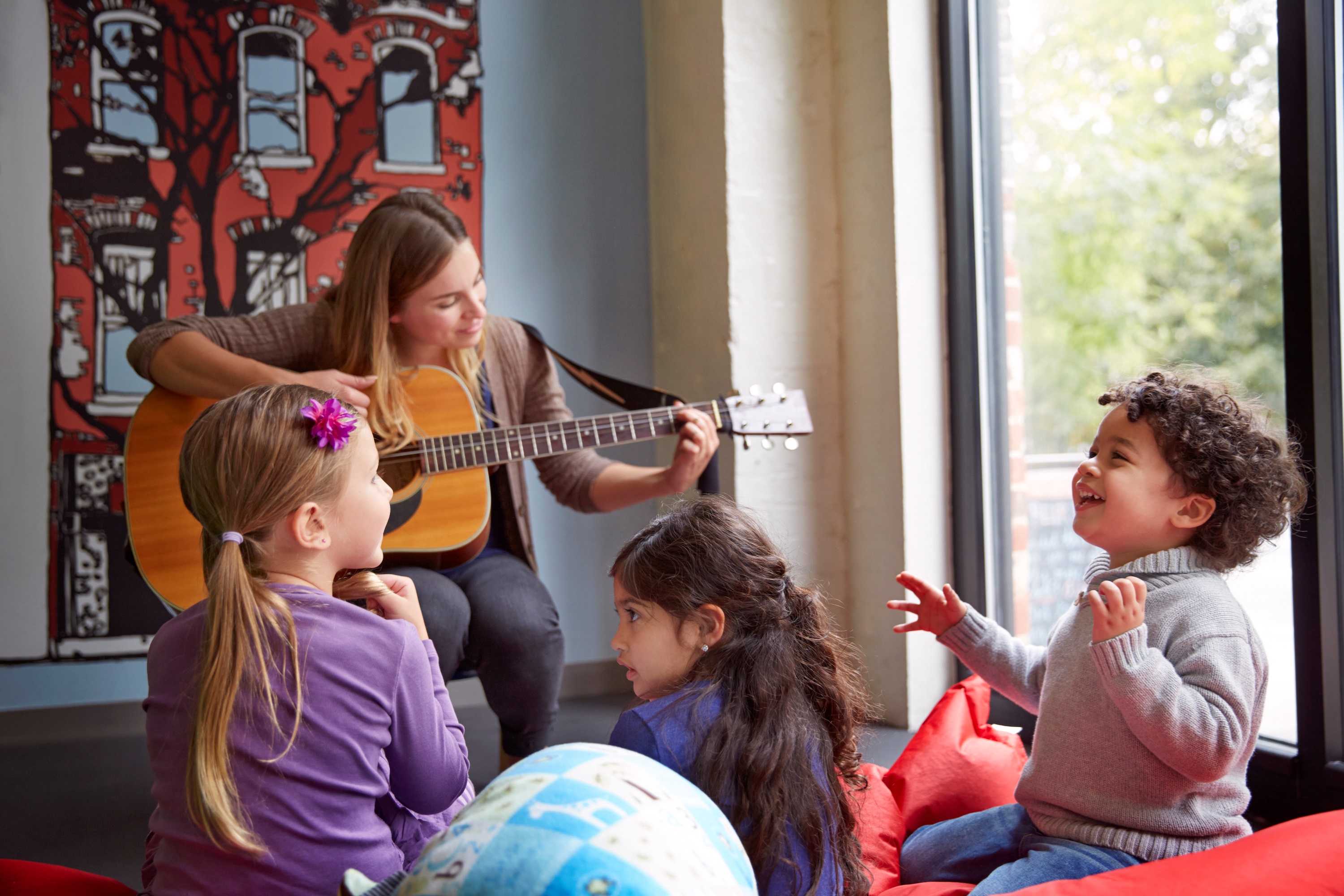 Teacher Playing Guitar to Group of Kids