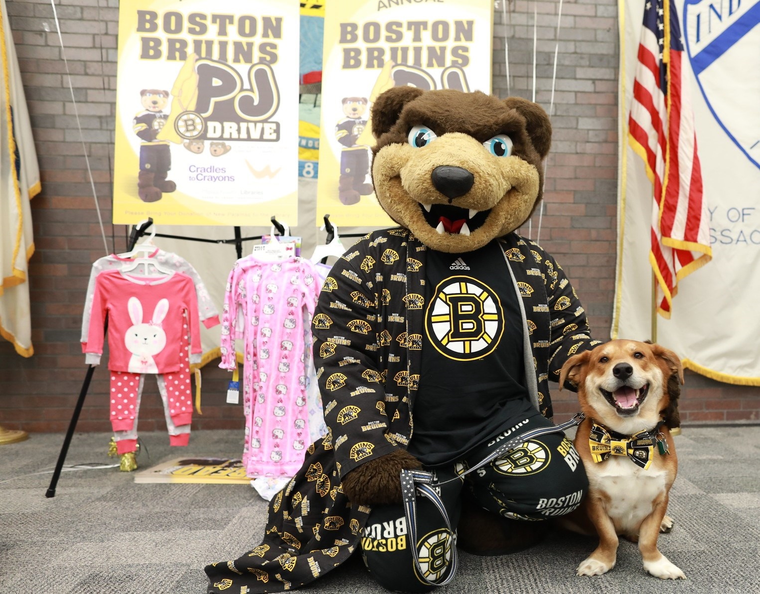 Bruins mascot Blades with therapy dog Oliver, posing in front of pajamas