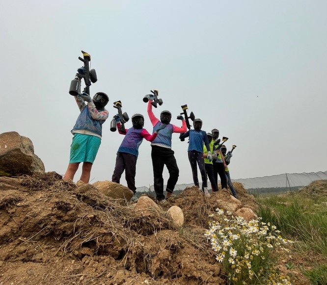 Group of paintballers on a mountaintop.
