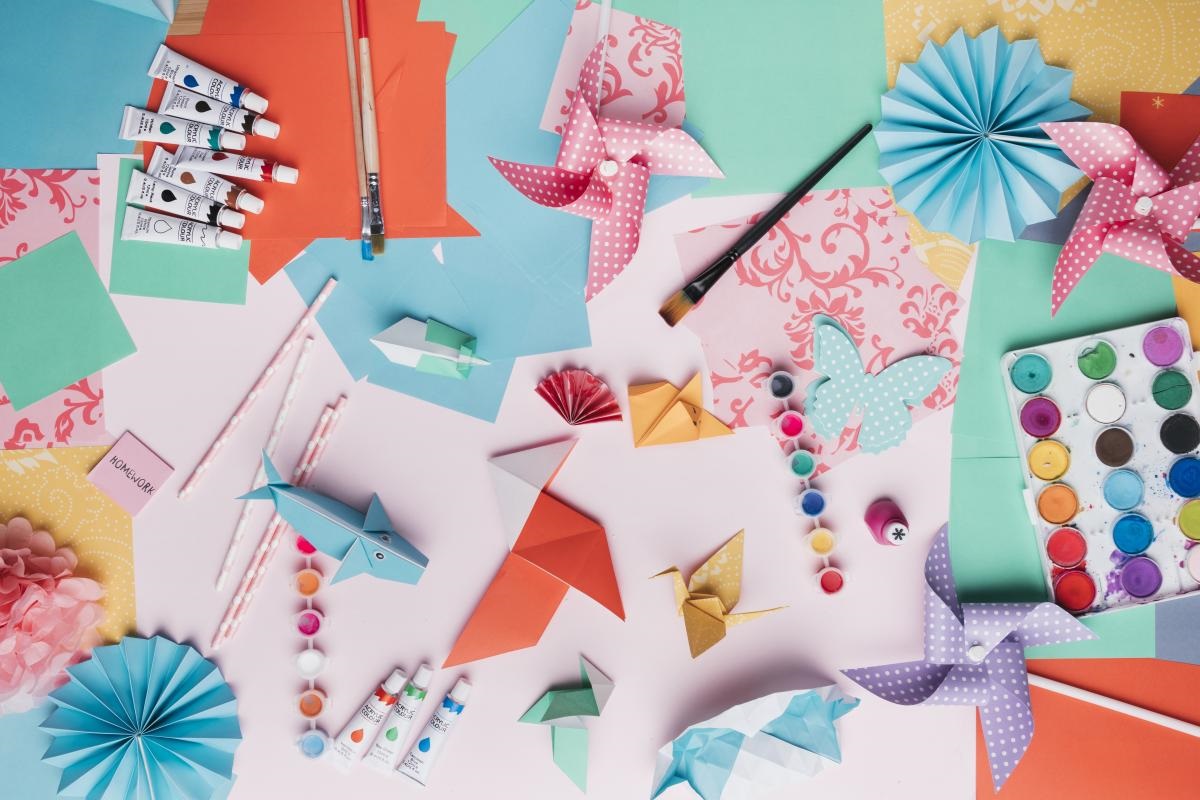 a collage of paint, paintbrushes, paper, origami animals