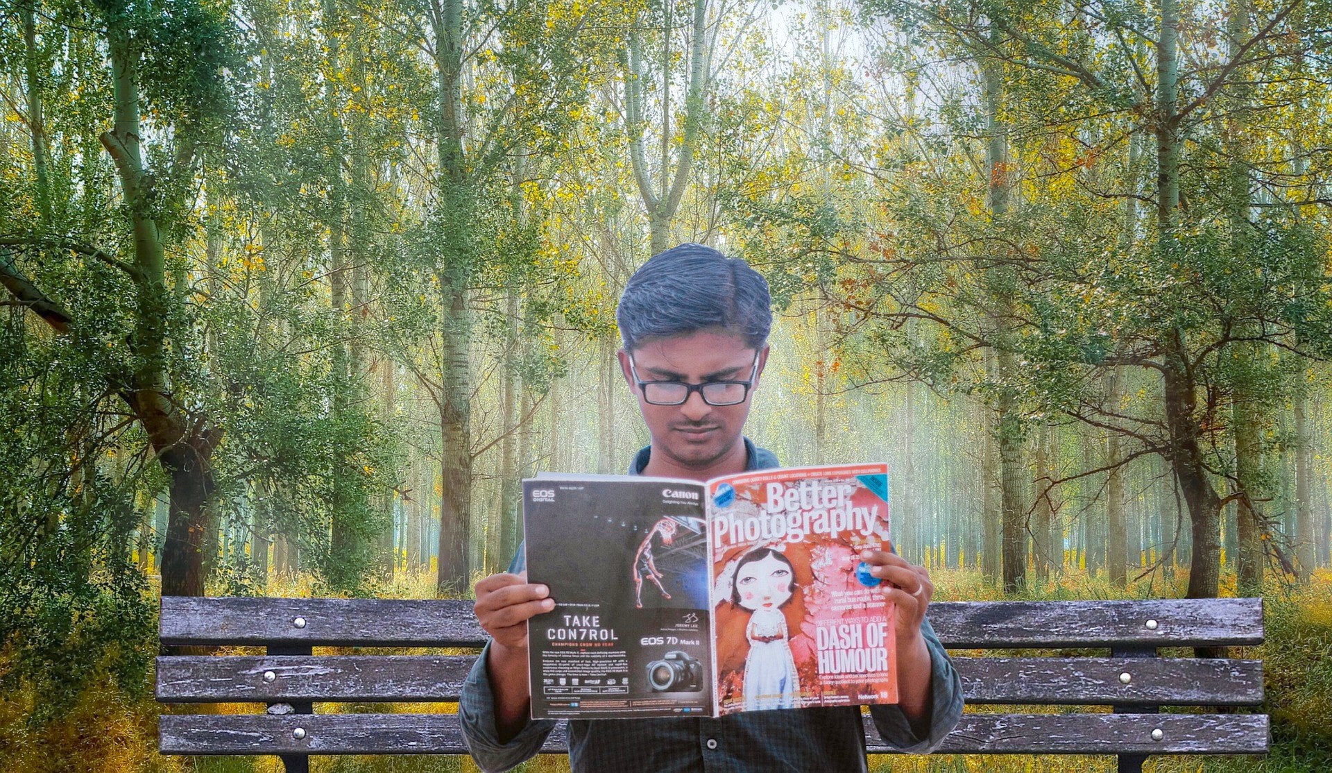 Man reading magazine on park bench