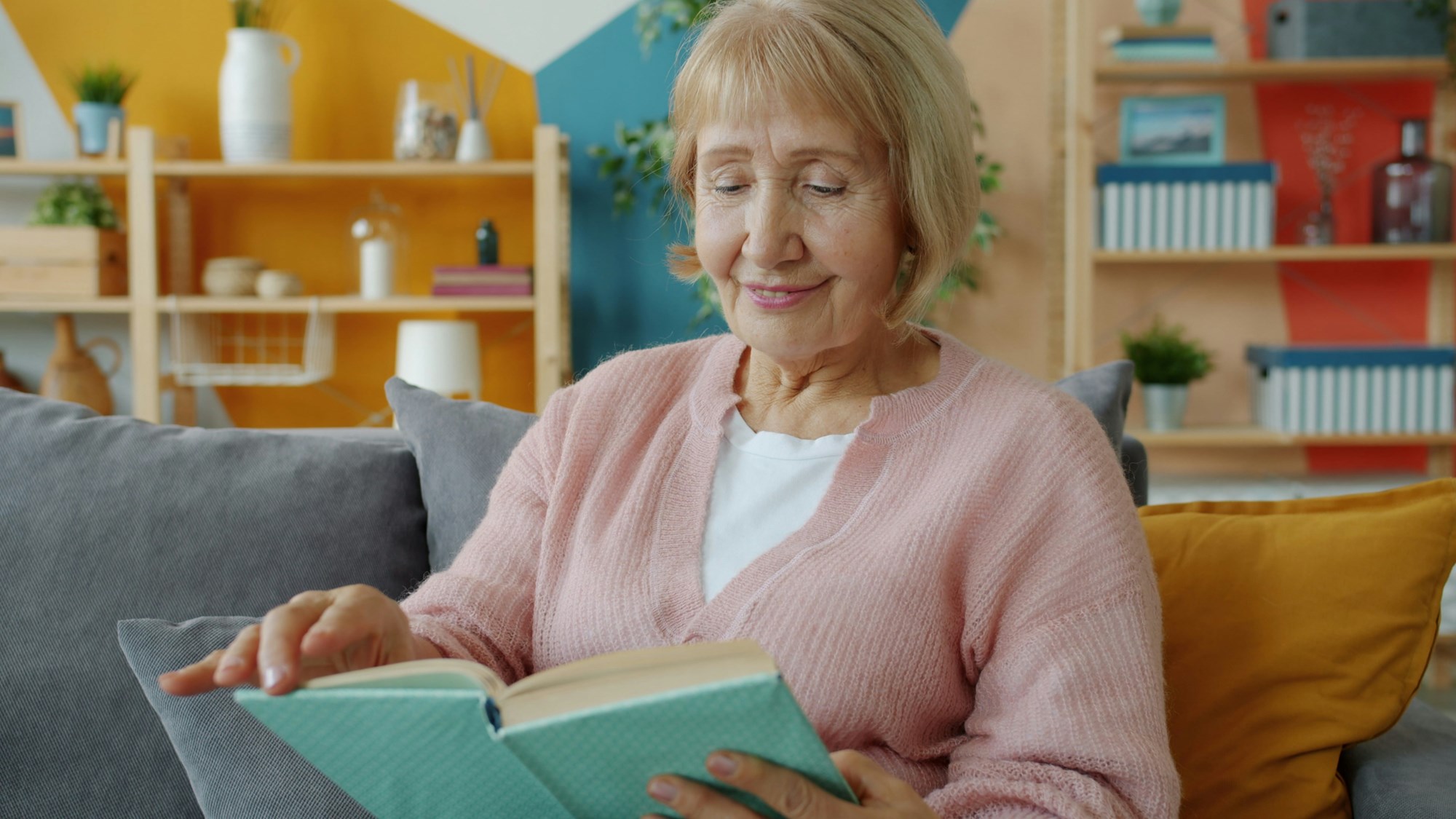 Senior Woman Reading a Book on a Couch
