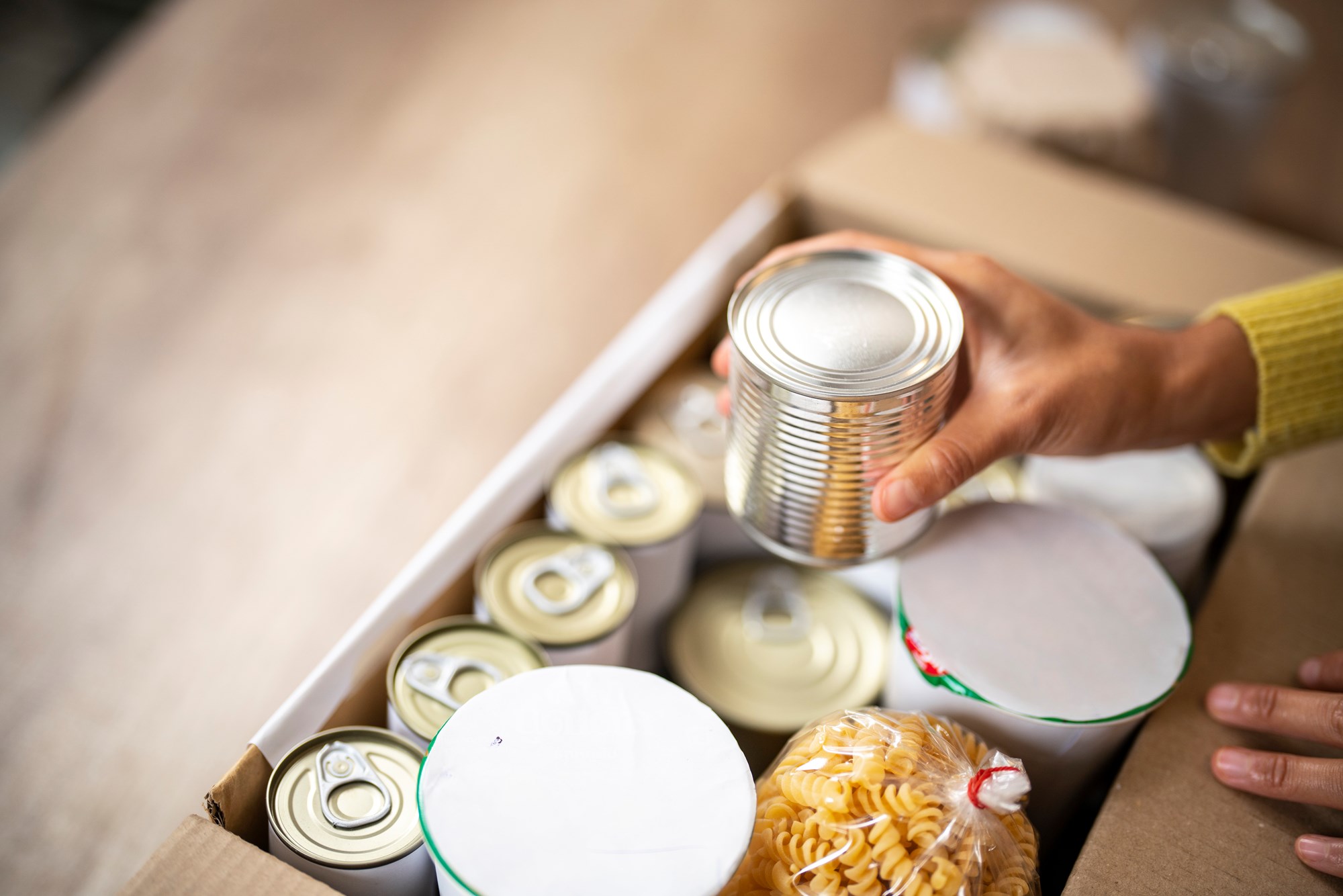 A Person Working at Charitable Foundation and Packing Donation Box