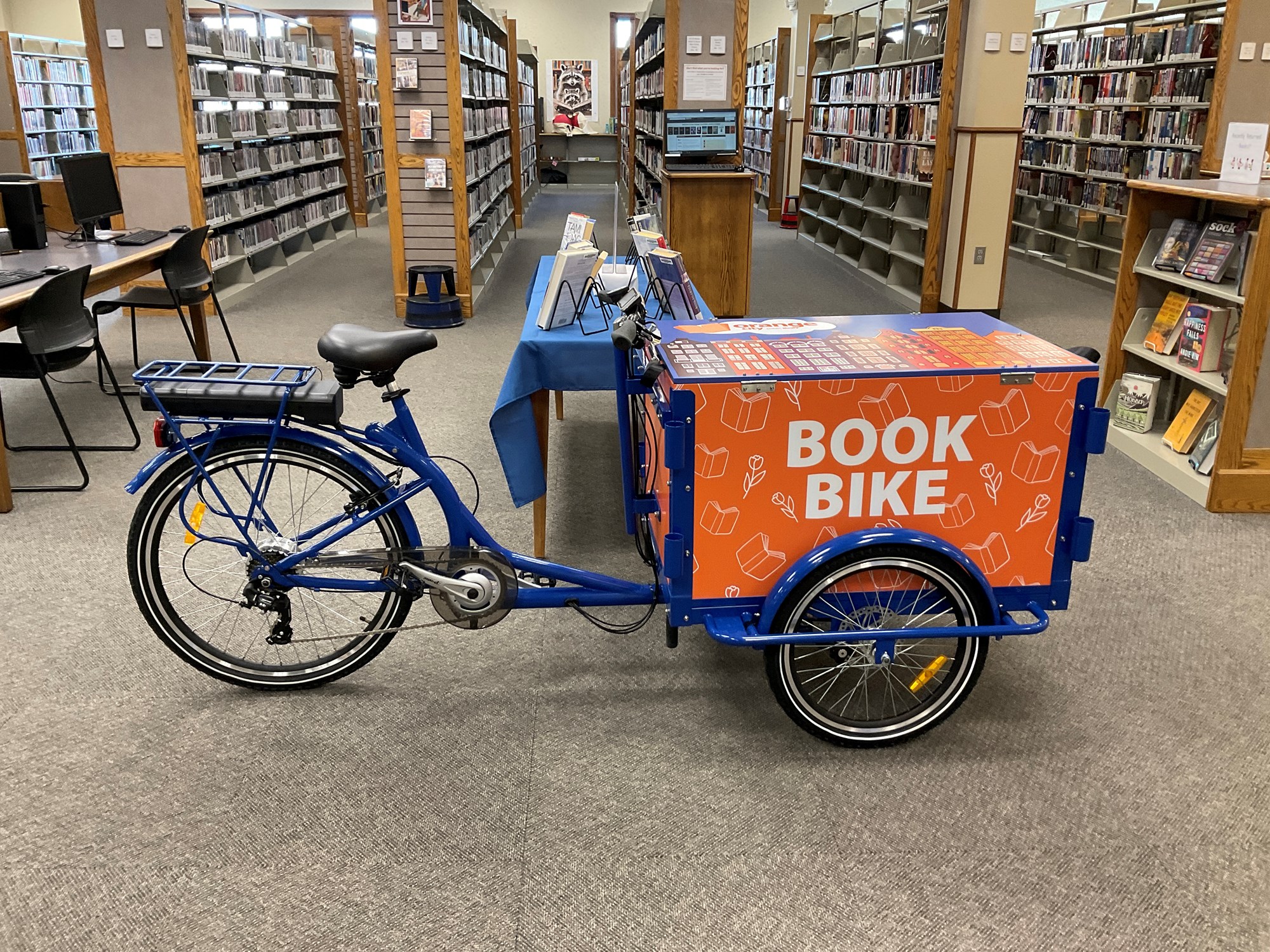 Photo of a blue bike with an orange box on front that says Book Bike