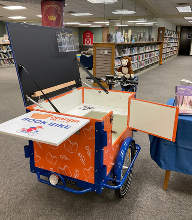 photo of book bike's front box opened to show the shelves and black board