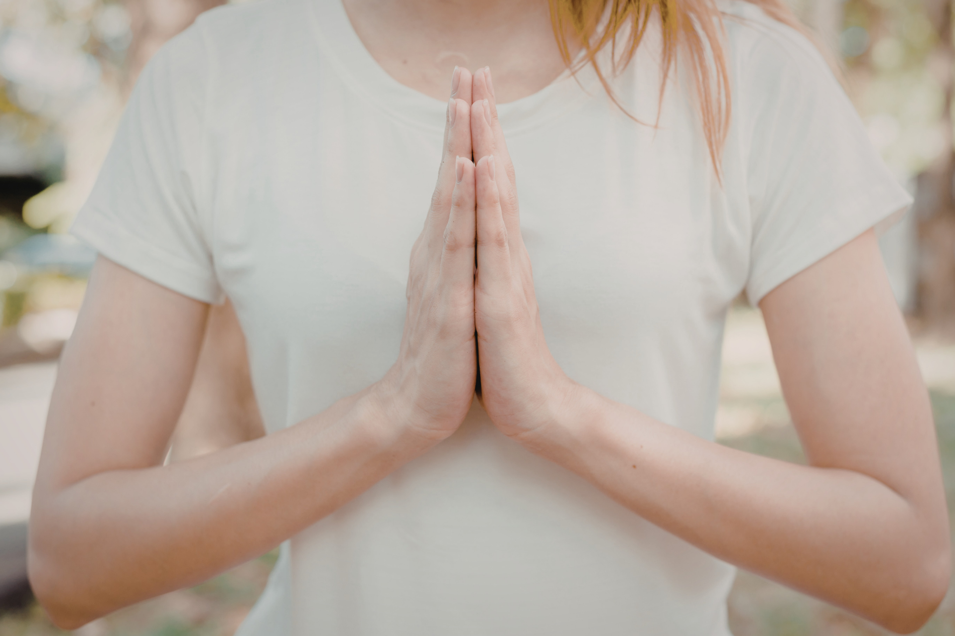 Woman with hands clasped together near heart